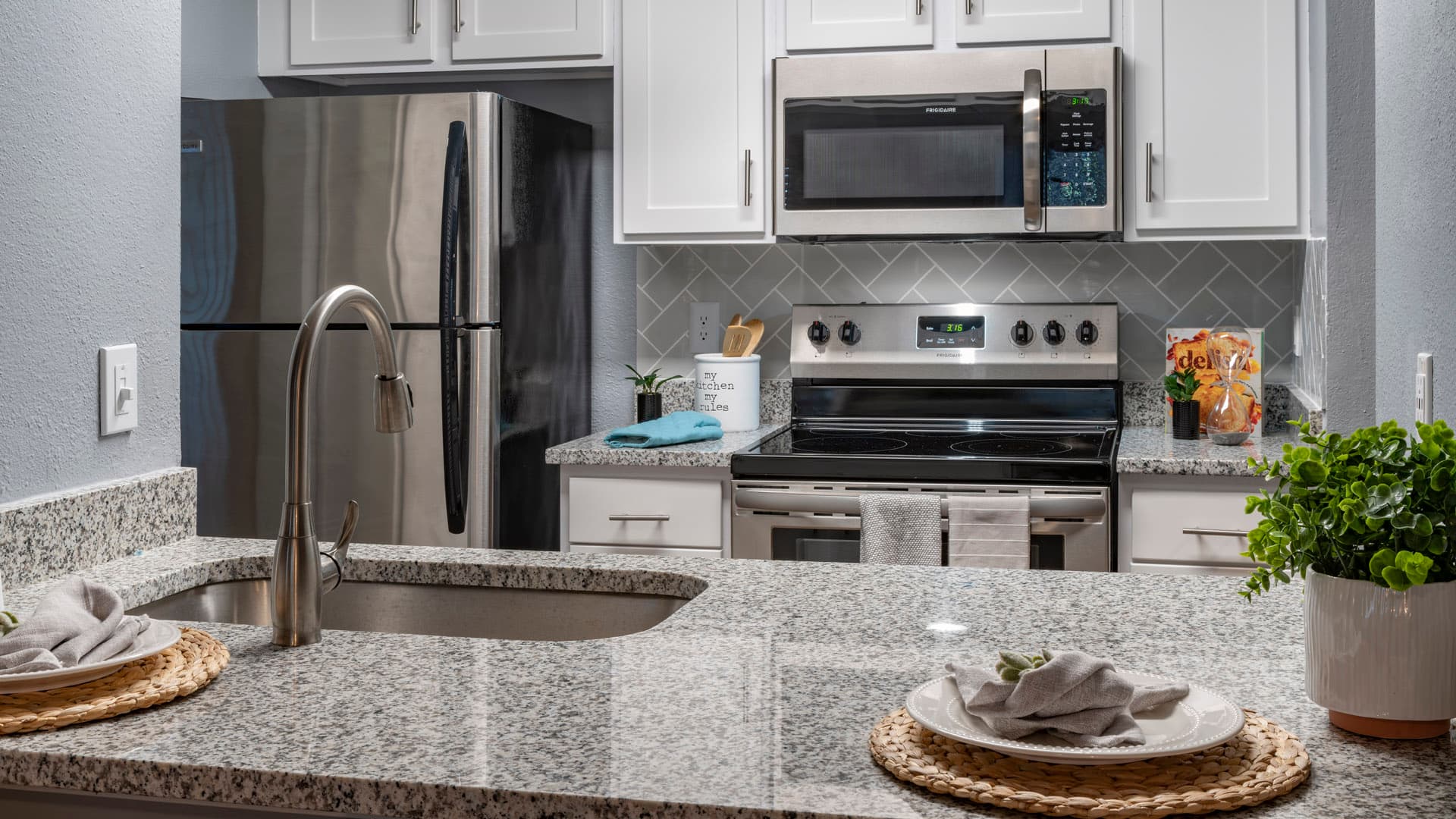 new quartz countertops, backsplash and stainless steel appliances in kitchen